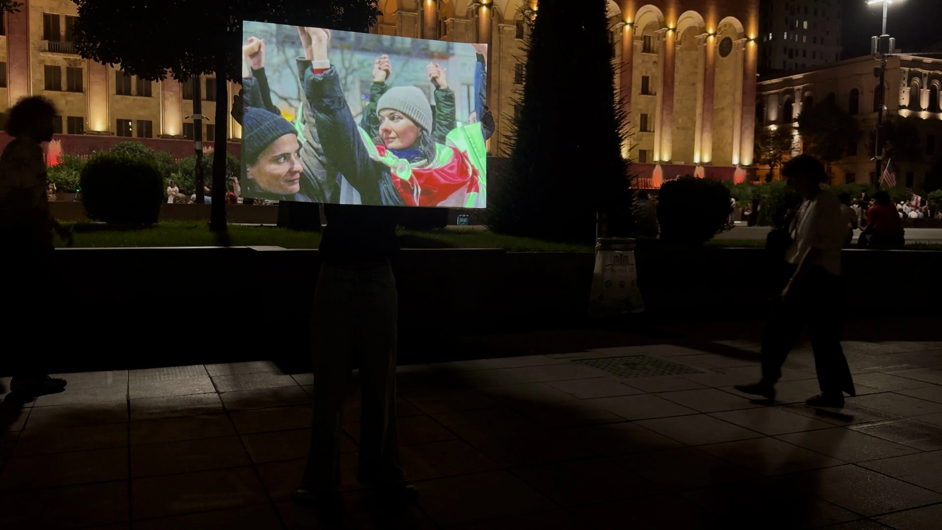 Girl with digital banner in front of Georgian Parliament, Tbilisi